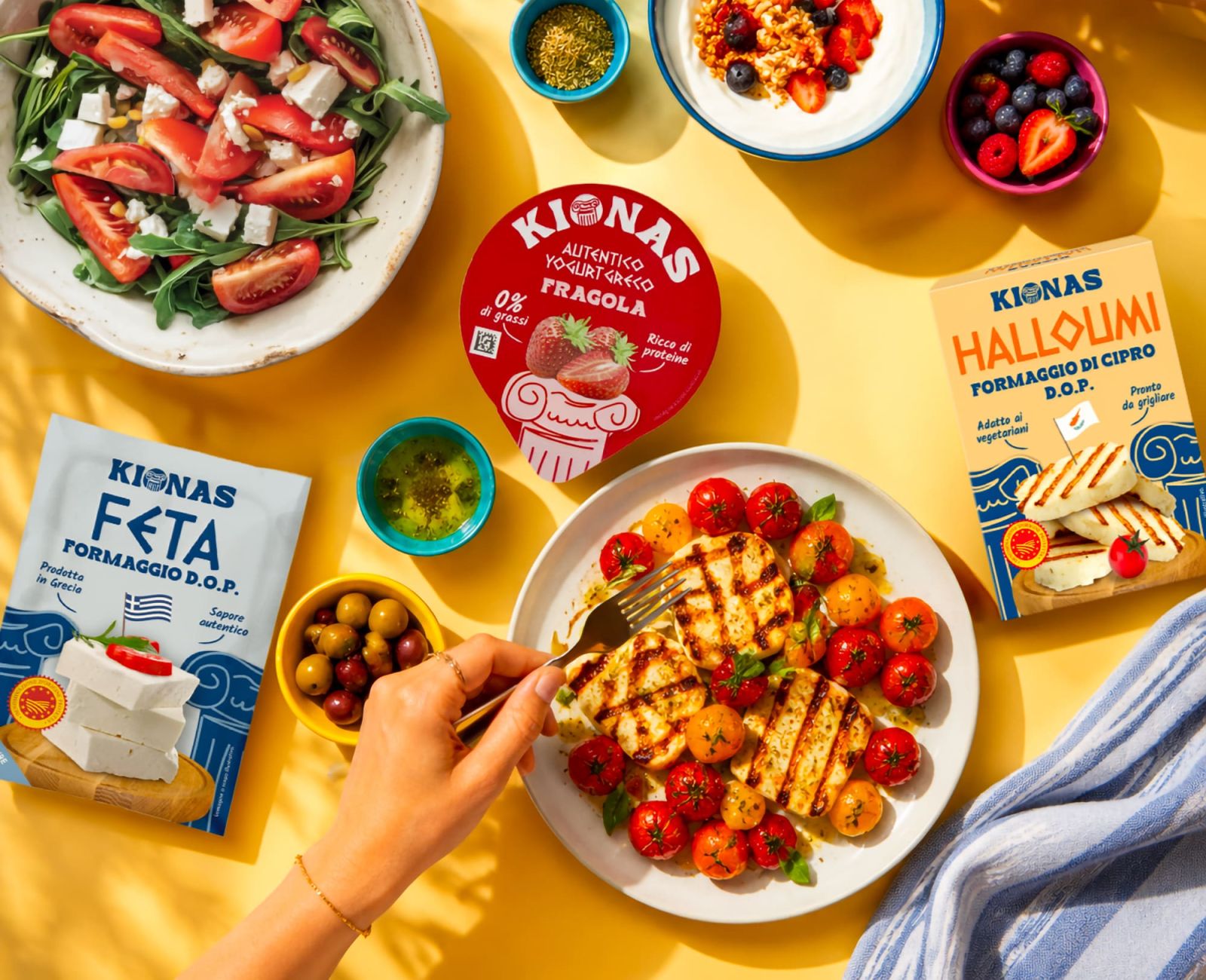 Tavola con yogurt greco Kionas, feta, halloumi, insalata e formaggio grigliato